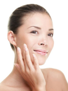 A woman touches her smooth skin - London skin expert, Sue Ibrahim from Elan Medical Skin Clinics in central London and Essex, soothes your skin this summer