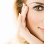 Beautif woman touches her smooth facial skin. If you have acne scars, speak to Sue Ibrahim, nurse consultant in dermatology at Elan Medical Skin Clinic to find out how she can help.