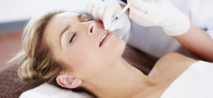 A woman has lip fillers - dermal fillers from Elan Medical Skin Clinics in central London and Essex can help improve smiles