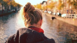 Young woman looks at a river. Suffering with acne? Call Sue Ibrahim at Elan Medical Skin Clinic in Essex for help and advice.